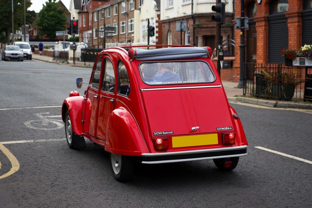 Novo conceito da Citroën transforma o 2 CV em laboratório de mobilidade urbana elétrica Citroën 2CV vermelho circula por uma rua urbana em Liverpool.