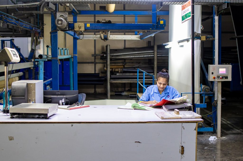 Pessimismo avança na indústria brasileira em setembro, mostra índice da CNI Trabalhadora analisa documentos de produção em uma fábrica têxtil.